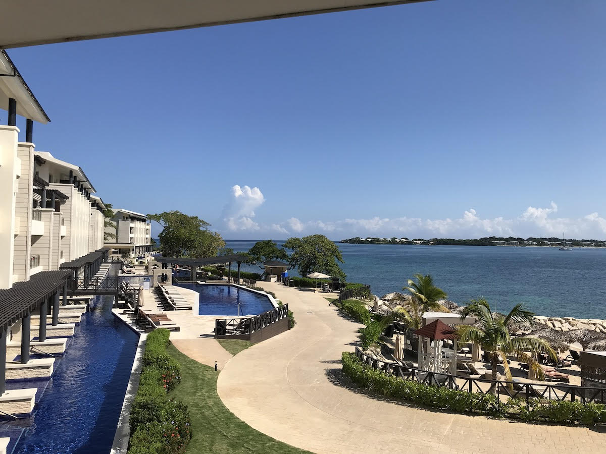 A panoramic view of the grounds and oceanfront scenery at The Royalton Hideaway in Jamaica. The property includes private pools, plenty of sunning areas, and direct access to the ocean