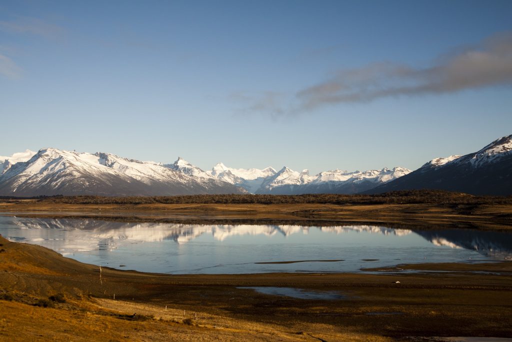 A lake with snow capped mountains in the background near the edge of the Southern Patagonian town of El Calafate, Argentina.