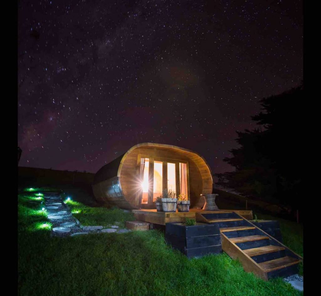 Ica View Glamping wooden cabin photographed at night with stars in the sky