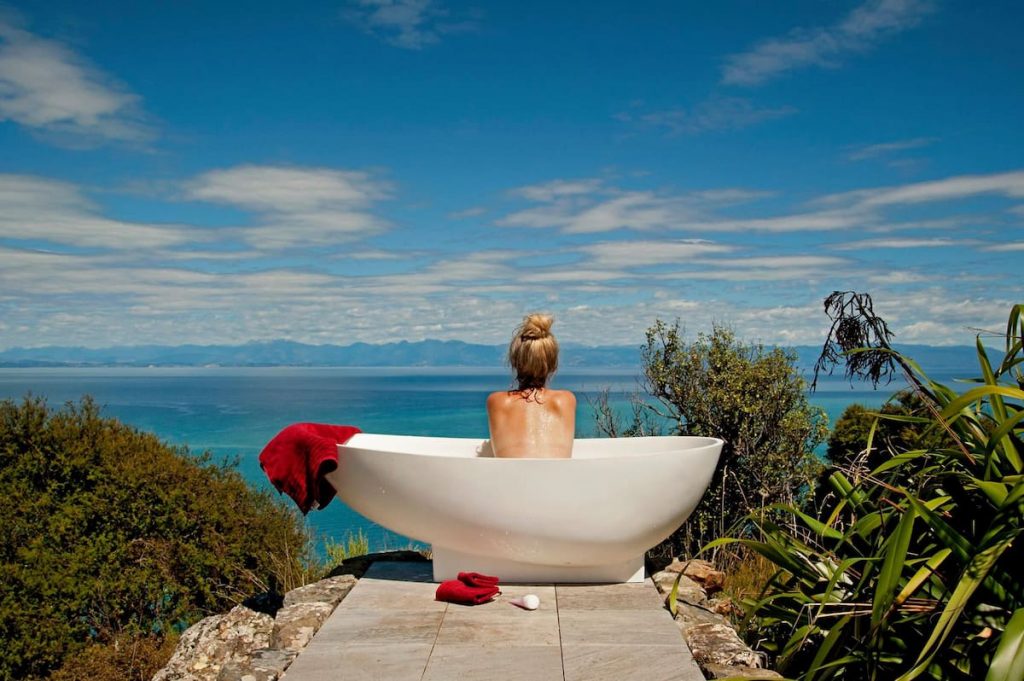 Rocky Point Hut a romantic & adventurous getaway with an outdoor soaking tub with a woman admiring the view