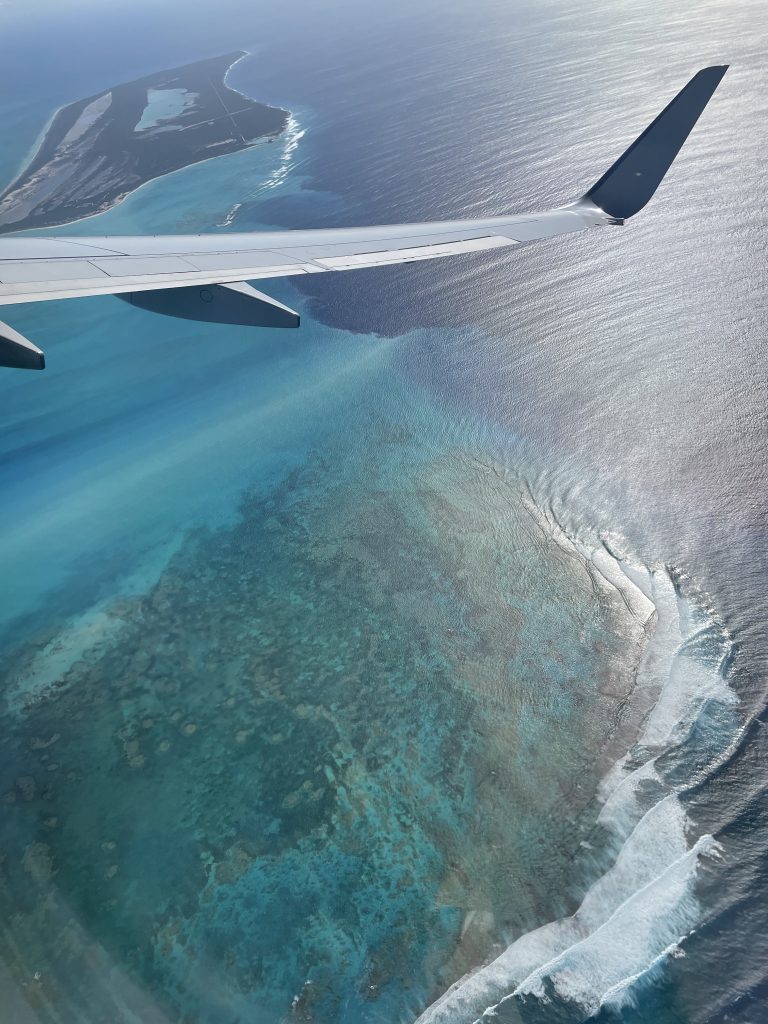 A view from an airplane when arriving at Turks and Caicos with crystal blue water beneath. 