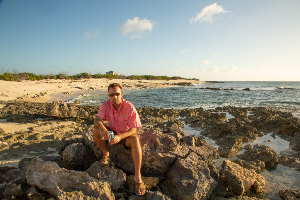 A man sitting on rocks near the ocean.