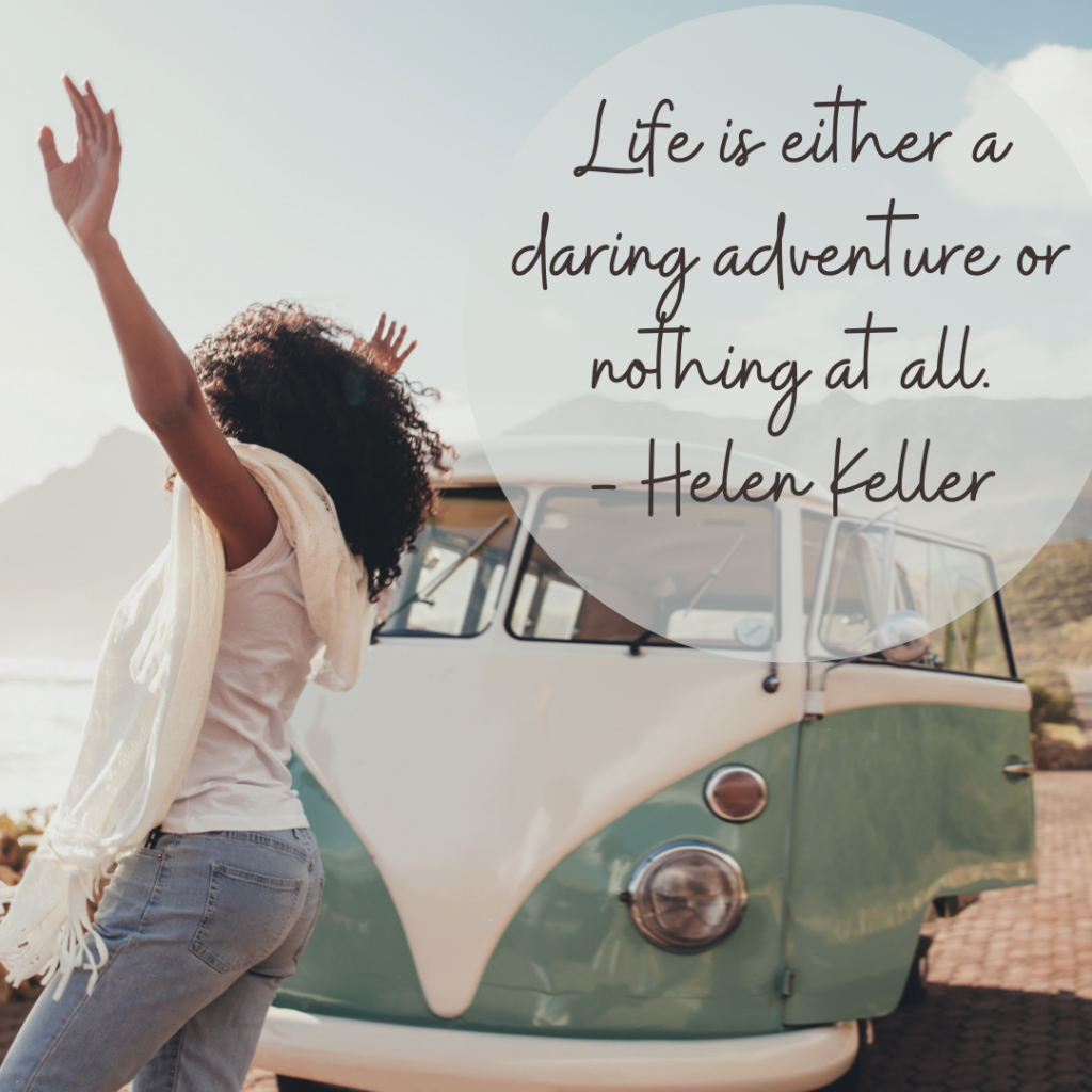 A woman stands in front of an old white and mint colored WV van, with her hands in the air and her back facing the camera. Black text on the image reads, "Life is either a daring adventure, or nothing at all. - Helen Keller"