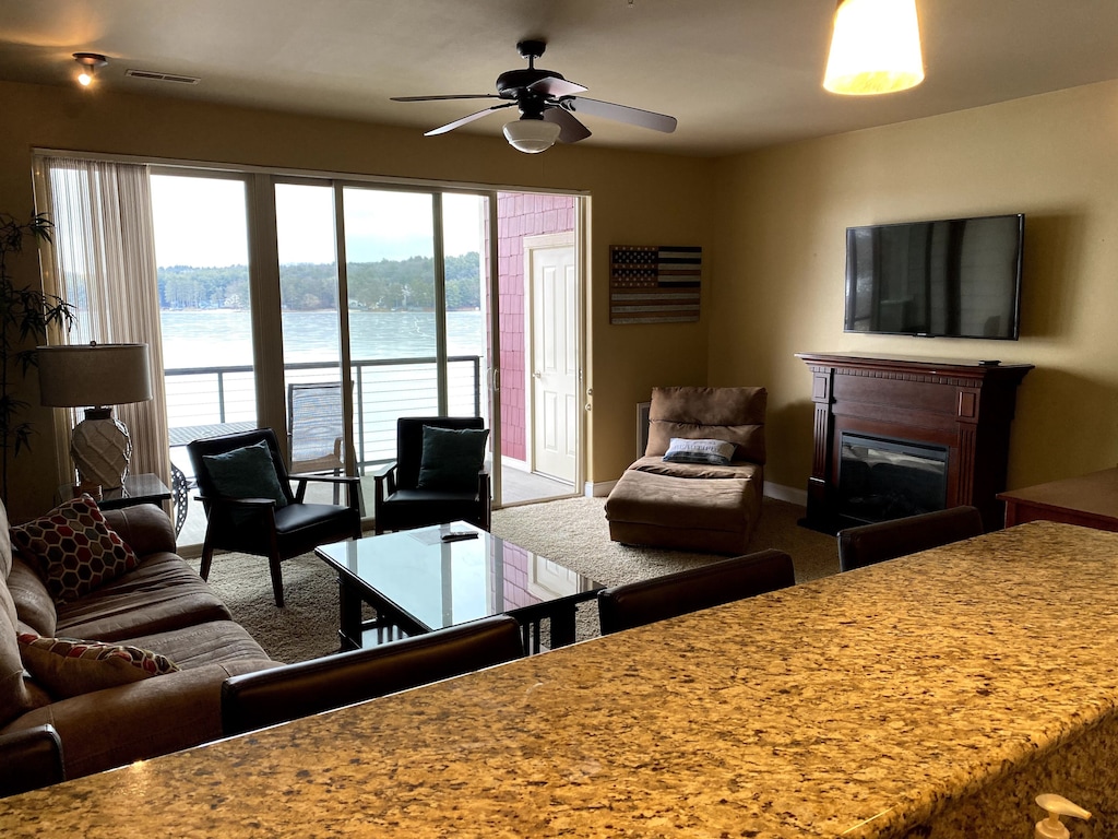 the inside of a classy private condo rental in the Wisconsin Dells featuring a cozy living room area and breakfast bar attached to a kitchen. A small private balcony overlooks the lake.