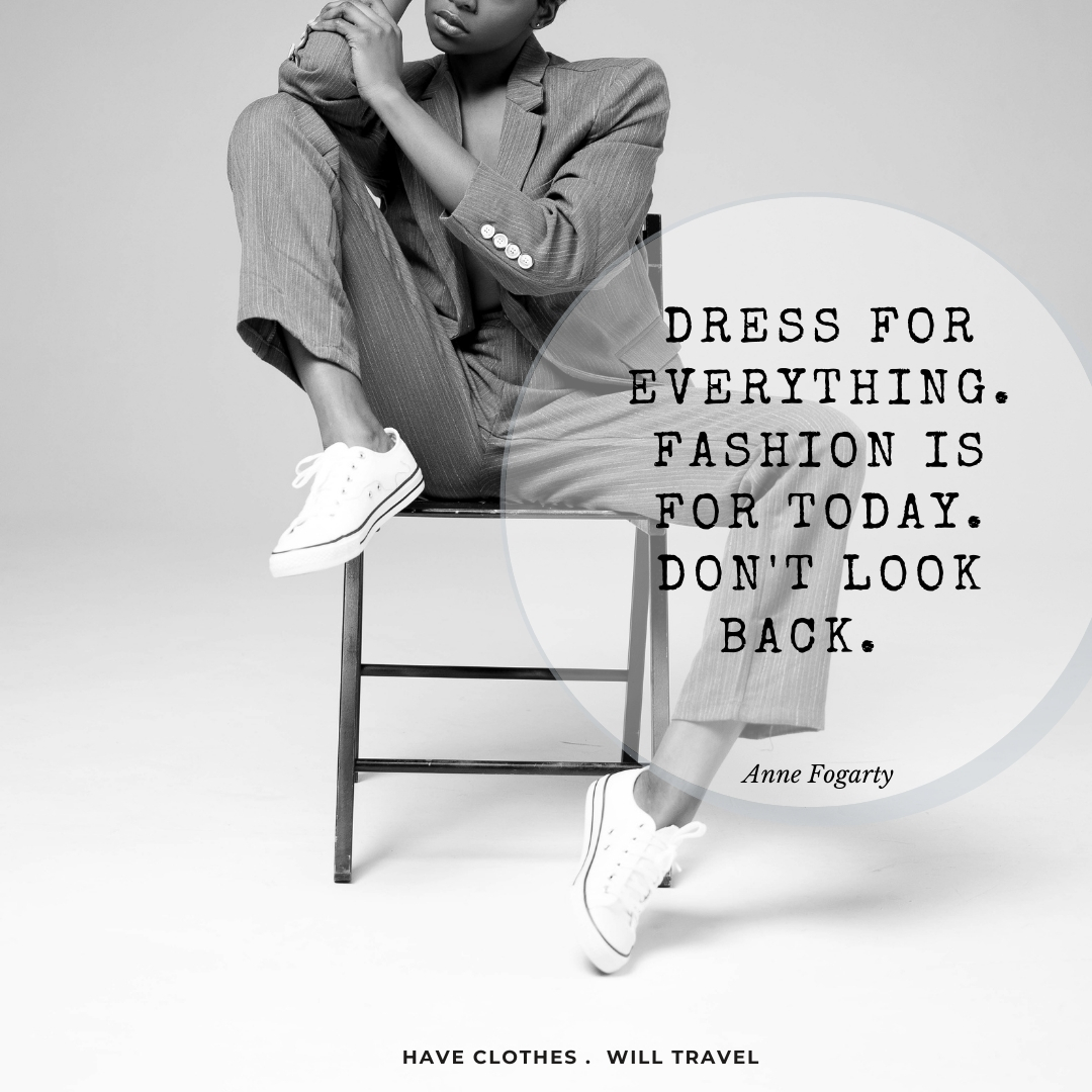 A black and white image of a black woman sitting on a chair in front of a white studio background. The model is wearing a suit and white Converse sneakers. Text on the image reads, "Dress for everything. Fashion is for today. Don't look back.  ― Anne Fogarty"