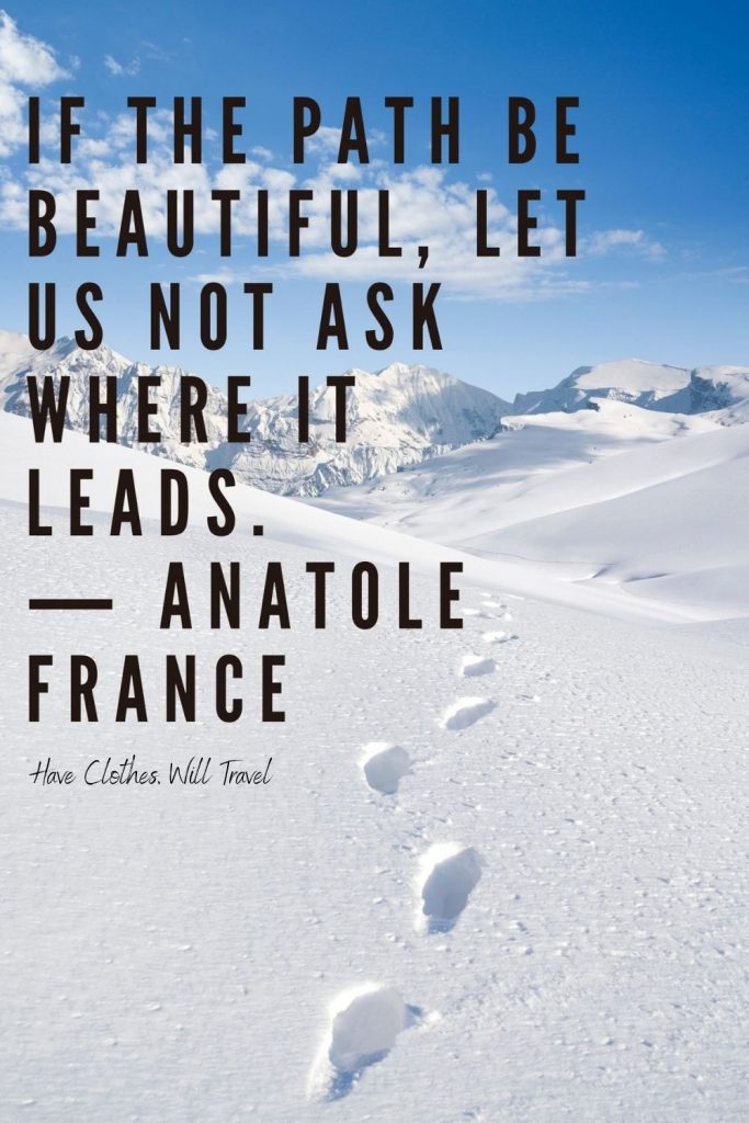 A landscape of snow-covered mountains, with footprints in the snow leading away from the viewpoint. Black text across the image says, "If the path be beautiful, let us not ask where it leads. - Anatole France"