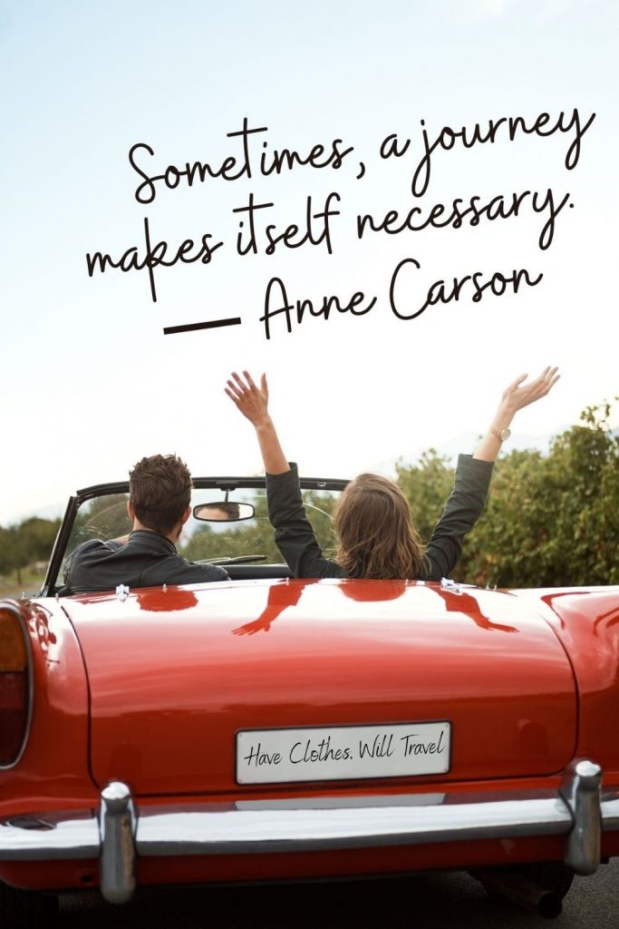 A man and woman drive in a convertible red sports car with top down. The woman has her hands in the art. Black text across the image says, "Sometimes, a journey makes itself necessary. - Anne Carson"