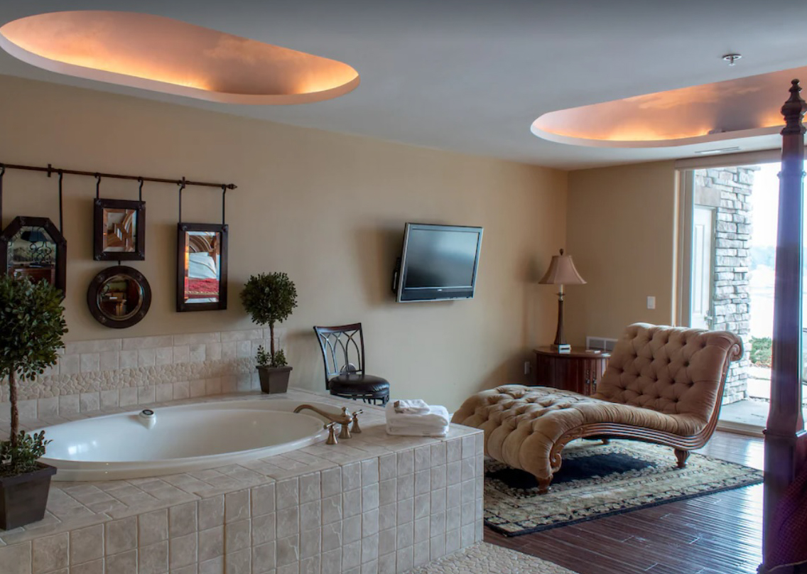 A relaxing indoor spa room with jacuzzi tub and chaise lounge inside a private lakefront condo rental in the Wisconsin Dells.