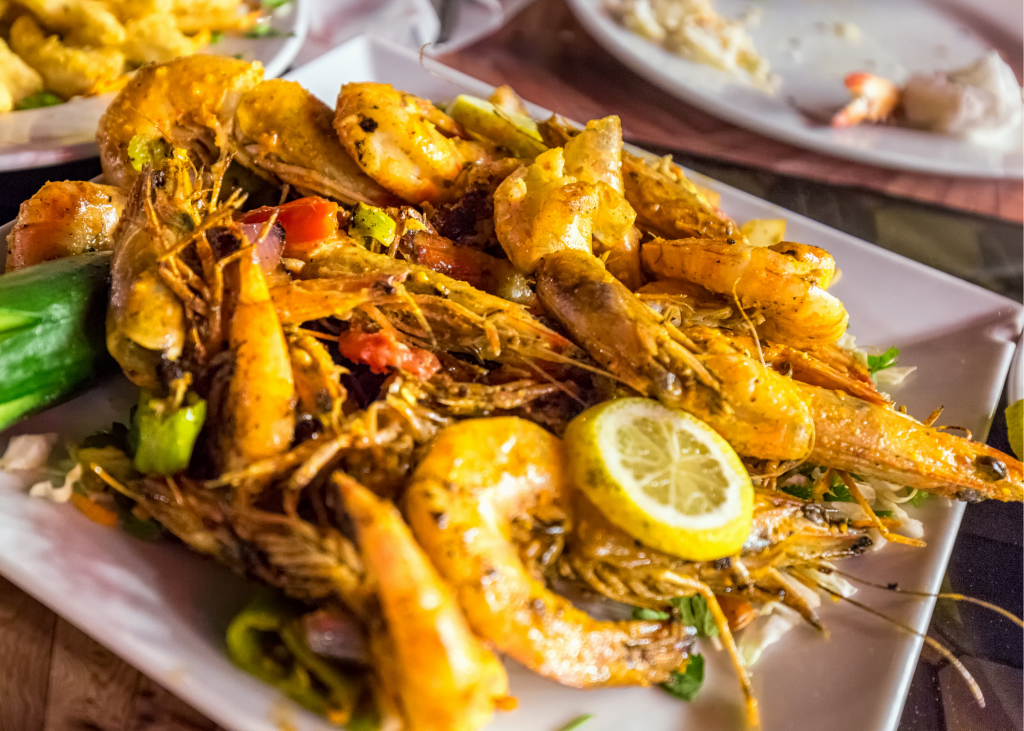 A plate of shrimp and vegetables on a table in a restaurant on Grace Bay.