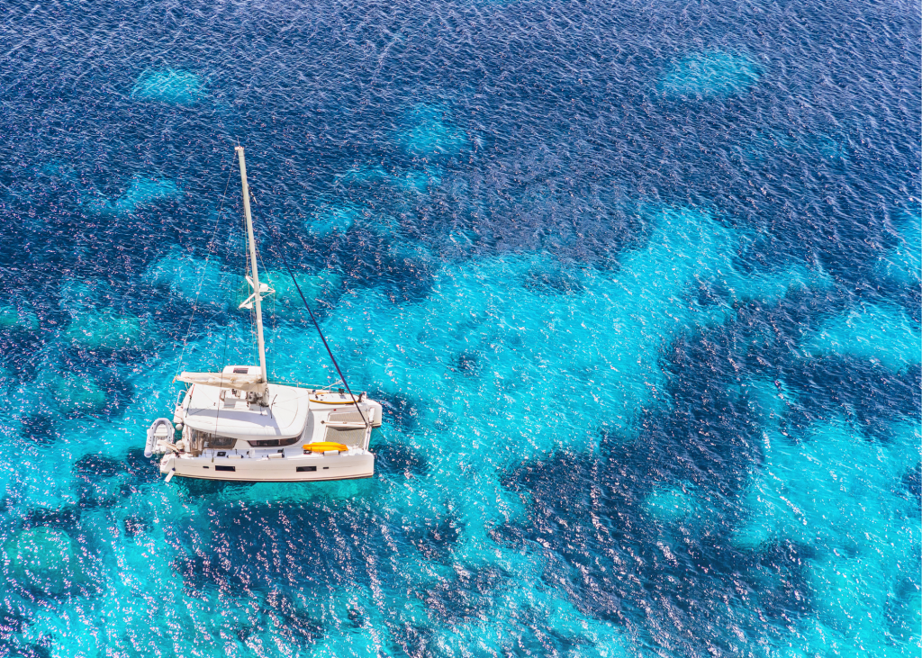 An aerial view of a catamaran in the ocean on Sapodilla Bay.