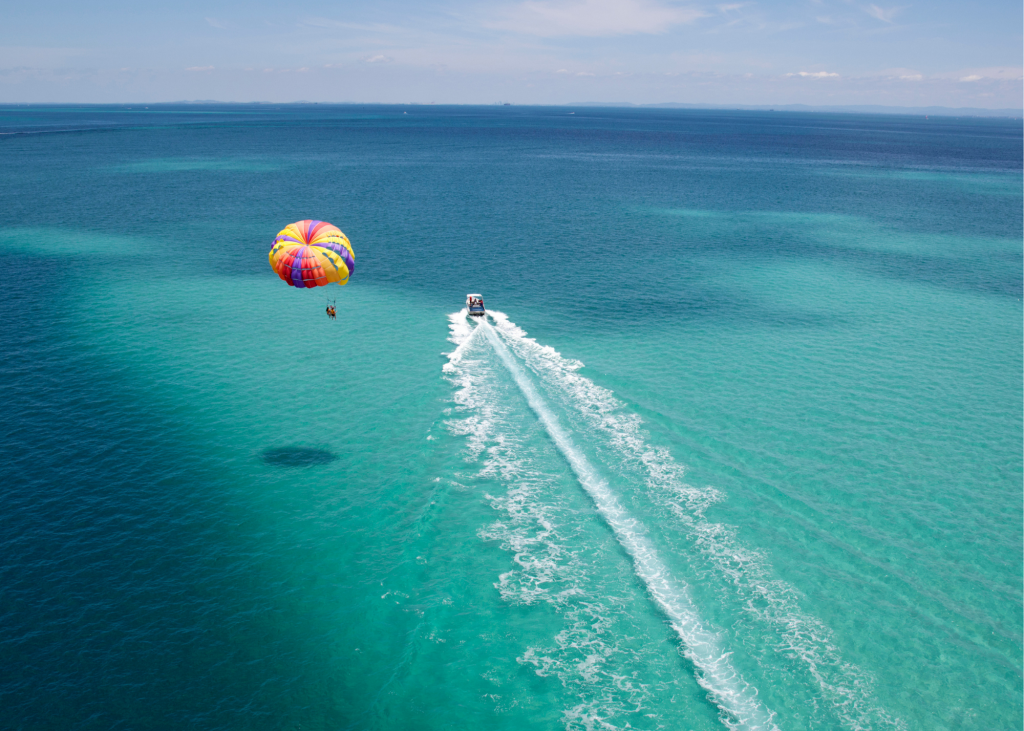 A boat with a parasail in the water.