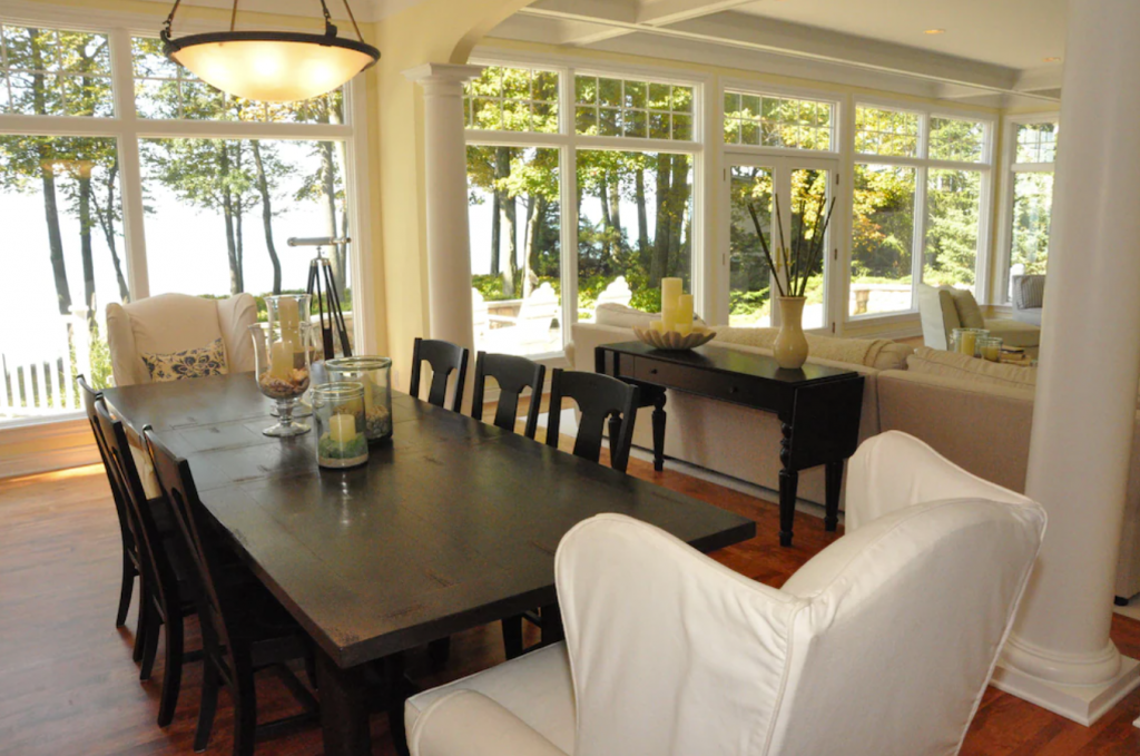 A dining room with a large table and chairs - Private 5-bedroom Beachfront with Landscaped Yard and Jacuzzi in Grand Haven.