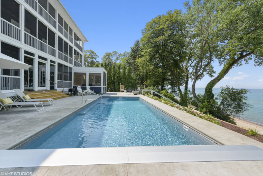 A house with a swimming pool next to the water - Modern 9-bedroom Lakefront Mansion with Heated Pool in Union Pier, Michigan.