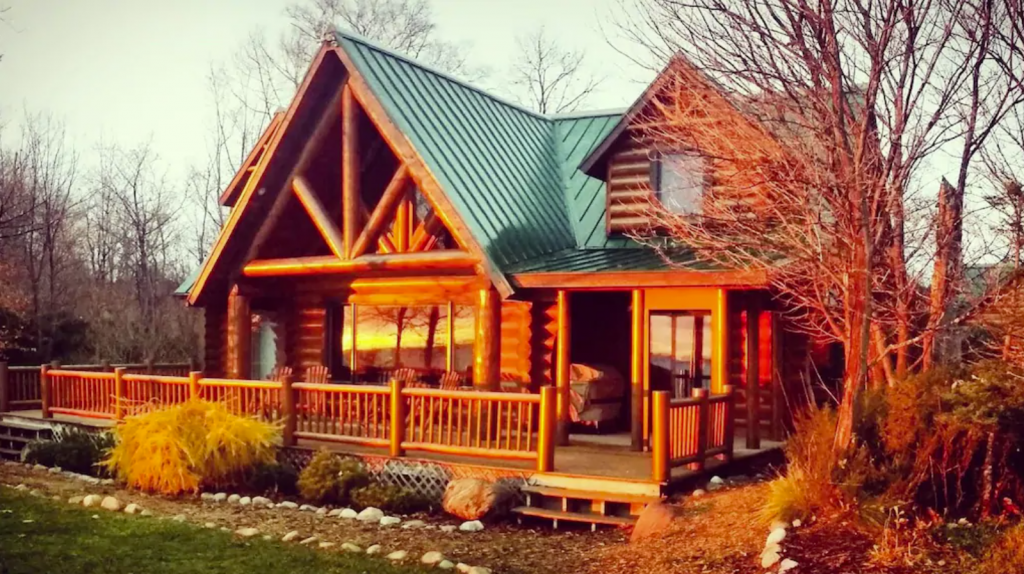 A log cabin in the woods with a green roof - Luxury Log Home on Lake Michigan.