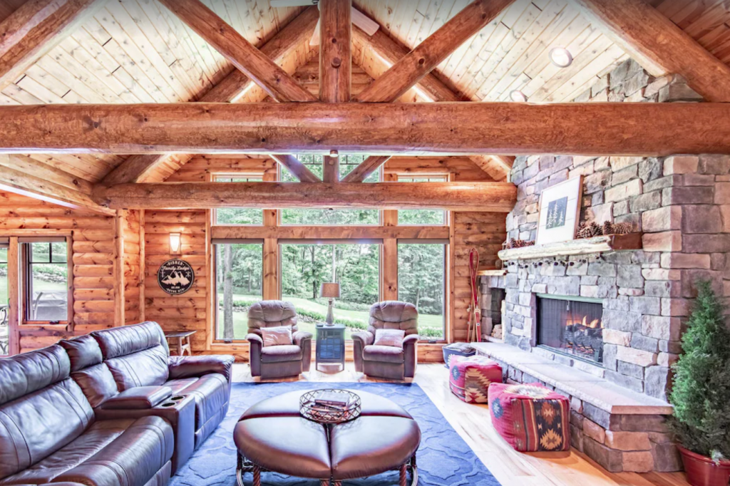 A living room in a log home with a fireplace - 5-bedroom Edelweiss Lodge in Exclusive Gated Community in Boyne Falls.