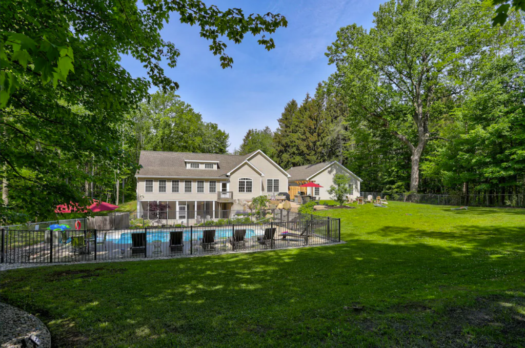 A wide angle view of a private 6-bedroom luxury home with pool in Fennville, Michigan.