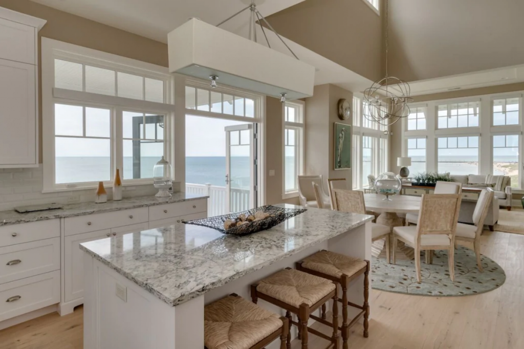 A white kitchen with a view of the ocean - Luxury Lakefront Home with Hot Tub and Outdoor Kitchen in South Haven.