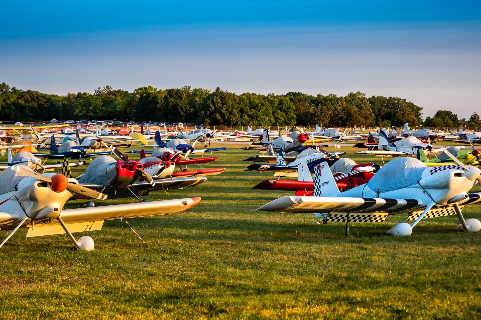 Rows of small passenger bush planes lined up in a field in Oshkosh, Wisconsin as part of the EAA AirVenture museum.