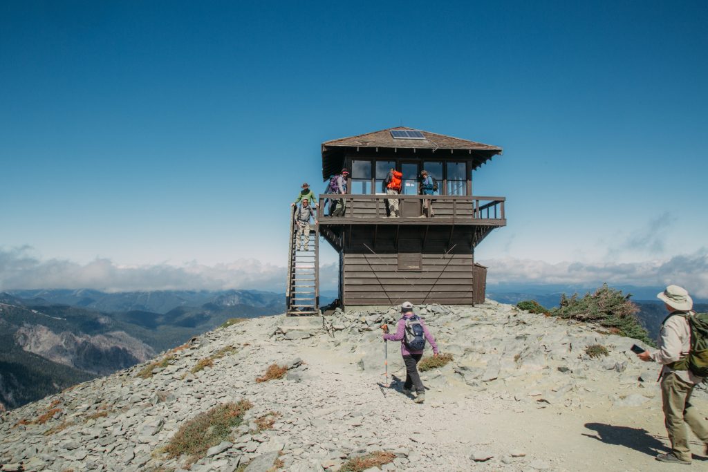 Hikers look in the windows of the closed Mt. Fremont Fire Lookout.