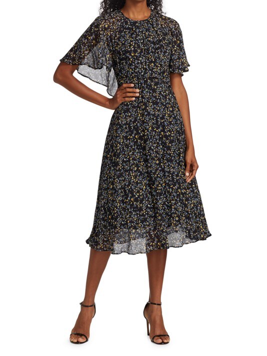 A black female model wears a black dress with a tiny detailed floral pattern. The dress is knee-length, has flutter sleeves, and roundneck neckline.