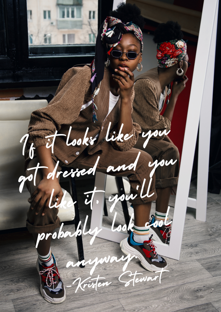 A young black woman sits on a stool in front of a floor-length mirror. She's wearing a floral head scarf, sunglasses, and brown corduroy jacket and pants. White text overlayed on the image reads, "If it looks like you got dressed and you like it, you'll probably look cool anyway. - Kristen Stewart