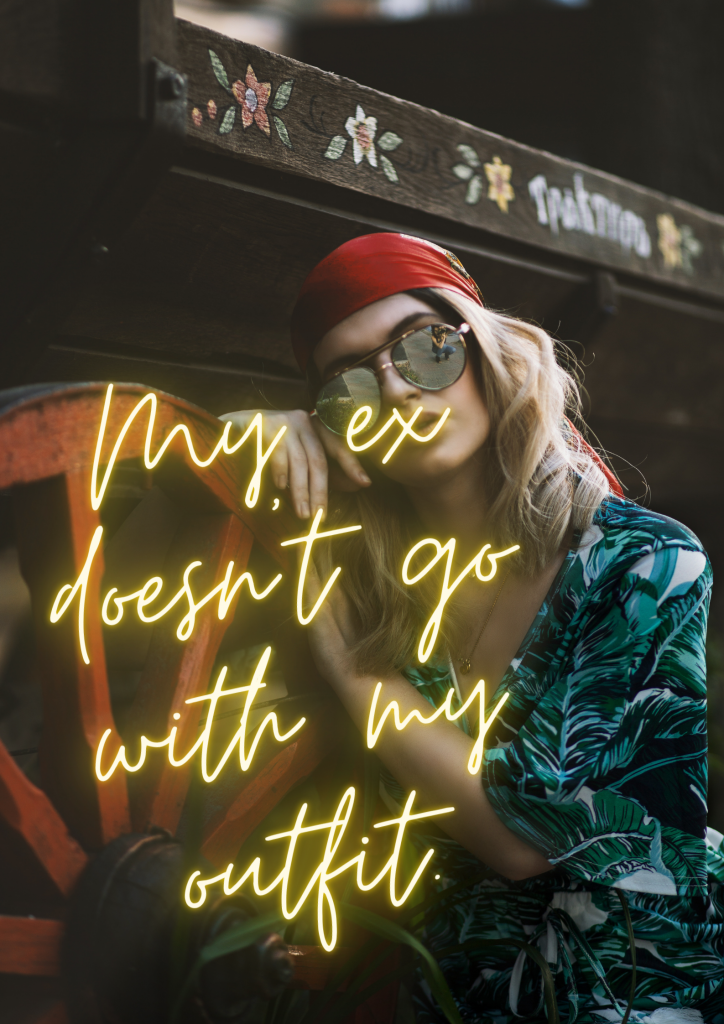 A young blonde woman poses next to a wooden wagon wheel. She's wearing a tropical leaf-patterned shirt, aviator sunglasses, and a red bandana over her hair. Glowing yellow cursive text on the image reads, "My ex doesn't go with my outfit."