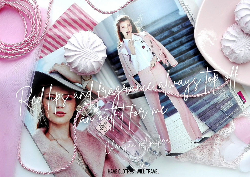 Editorial pages from a magazine feature a model wearing a pink business-casual outsit. Pink accessories - a necklace, perfume bottle, earrings, and meringue cookies - surround the pages. White text overlayed on the image reads "Red lips and fragrance always top off an outfit for me. - Christina Aguilera"