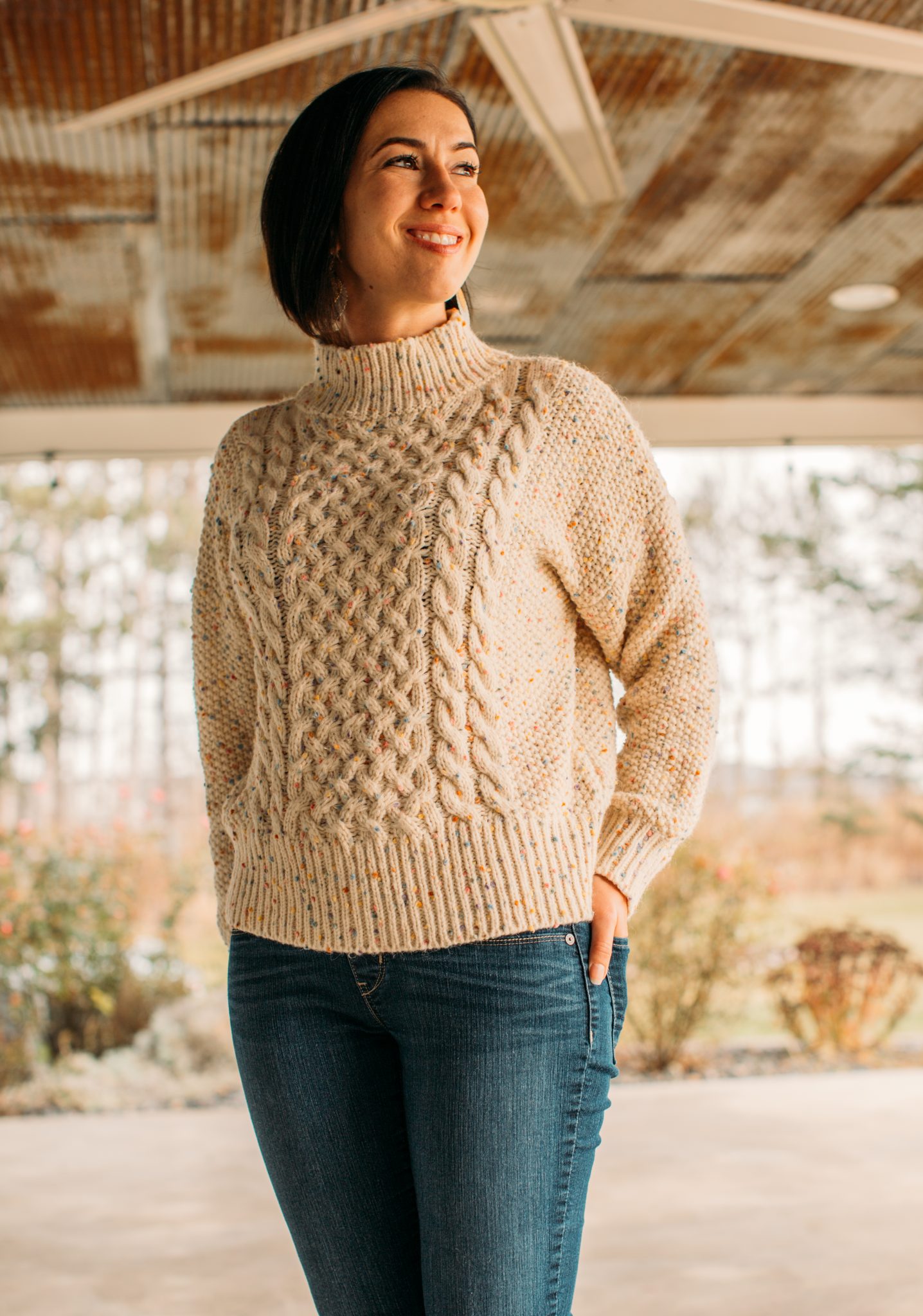 A woman wearing a colorful dots high neck chunky knit sweater from Chicwish.