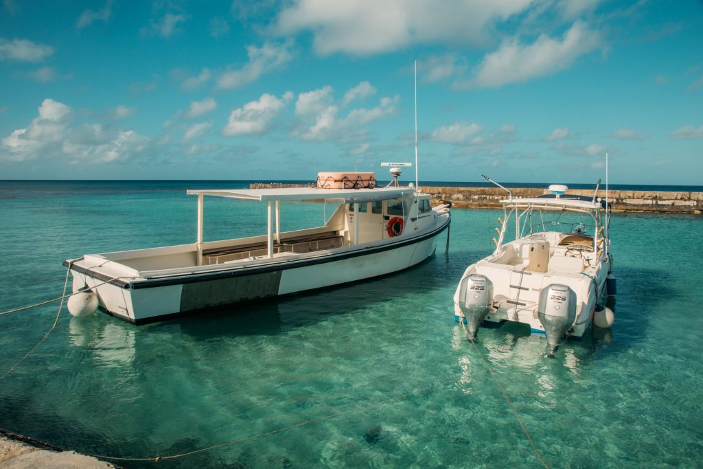 The ferry used between salt cay and grand turk floating beside another personal boat in the ocean.