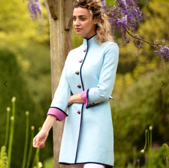 Woman with blonde curly hair wearing an Ice Blue Linen Cavalier Coat from Wolf and Badger