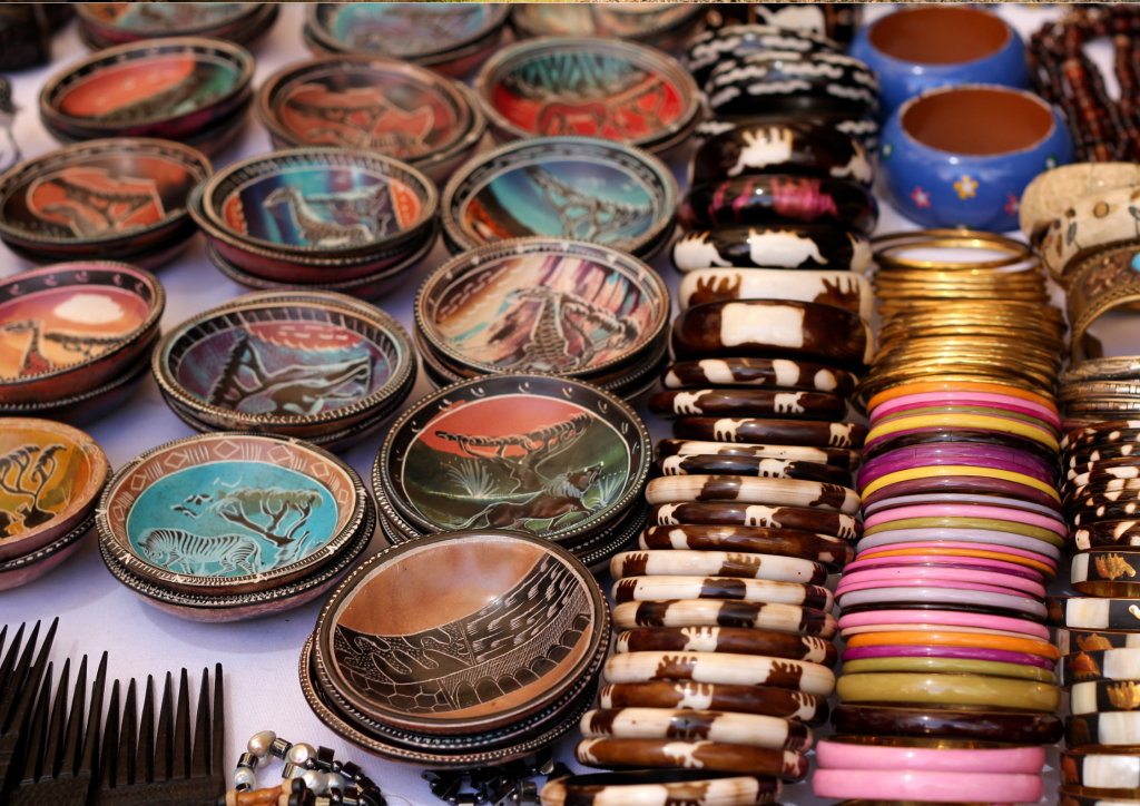 A variety of colorful bowls and bangles are displayed on a table in Maasai Market.