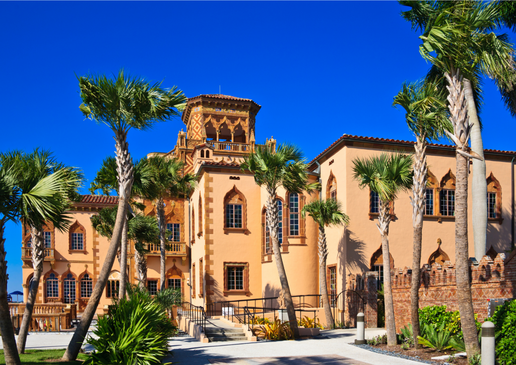 A large building with palm trees in front of it.