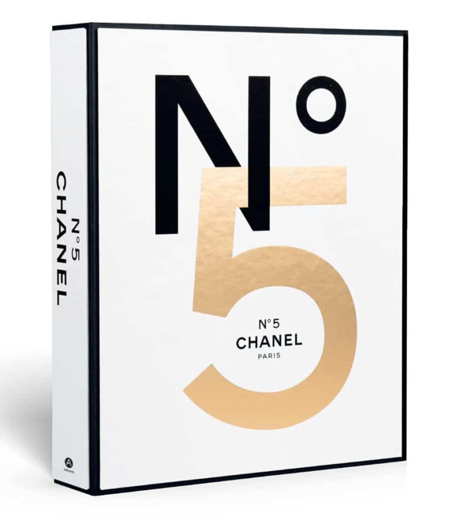 Hardcover fashion and designer book titled Chanel No. 5: Story of a Perfume by Pauline Dreyfus with gold, black, and white book cover design