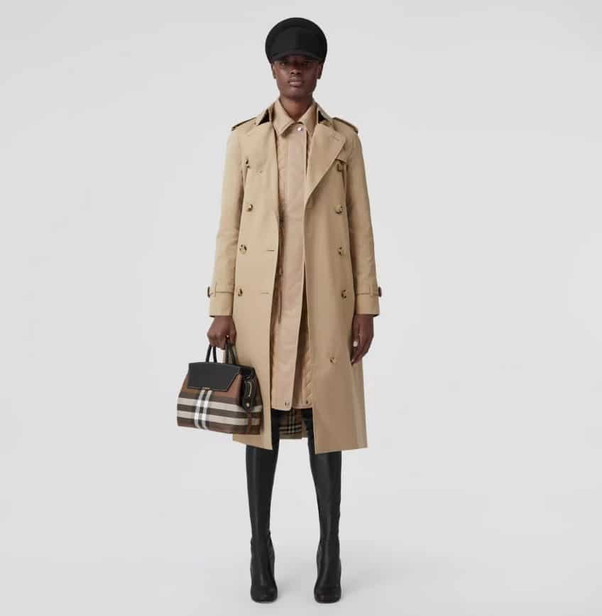 The woman is wearing a trench coat and a bag.