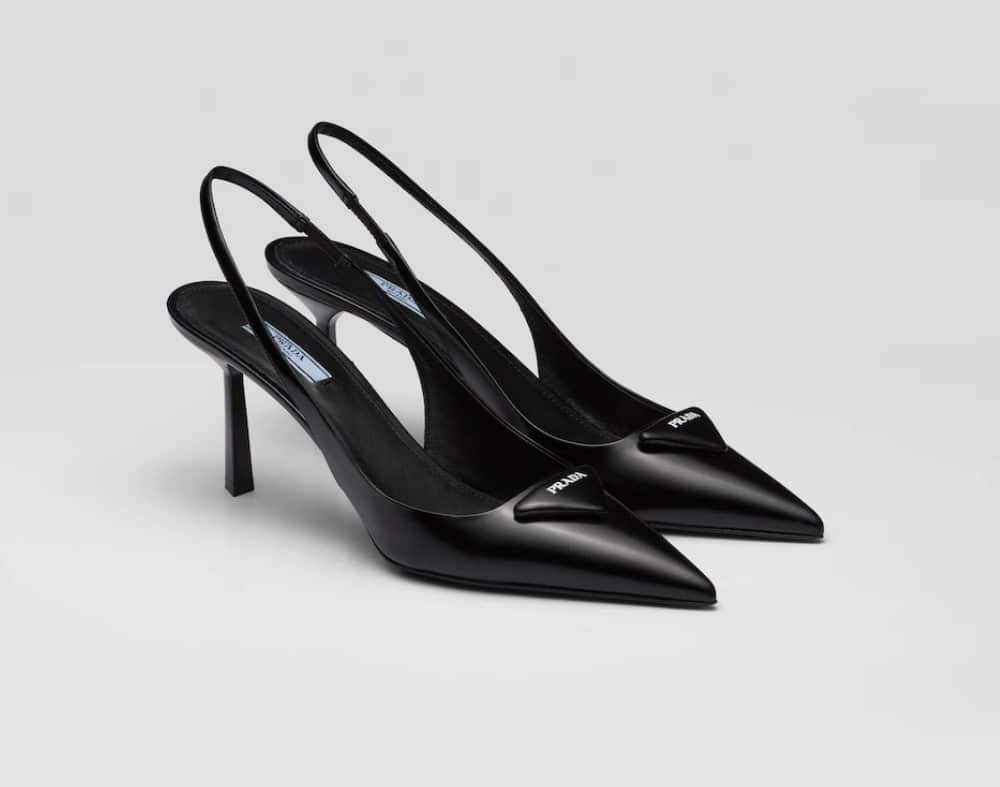 A pair of black slingback pumps on a white background.