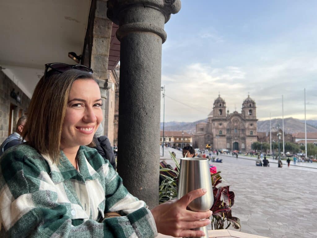 A woman holding a glass in front of a city.