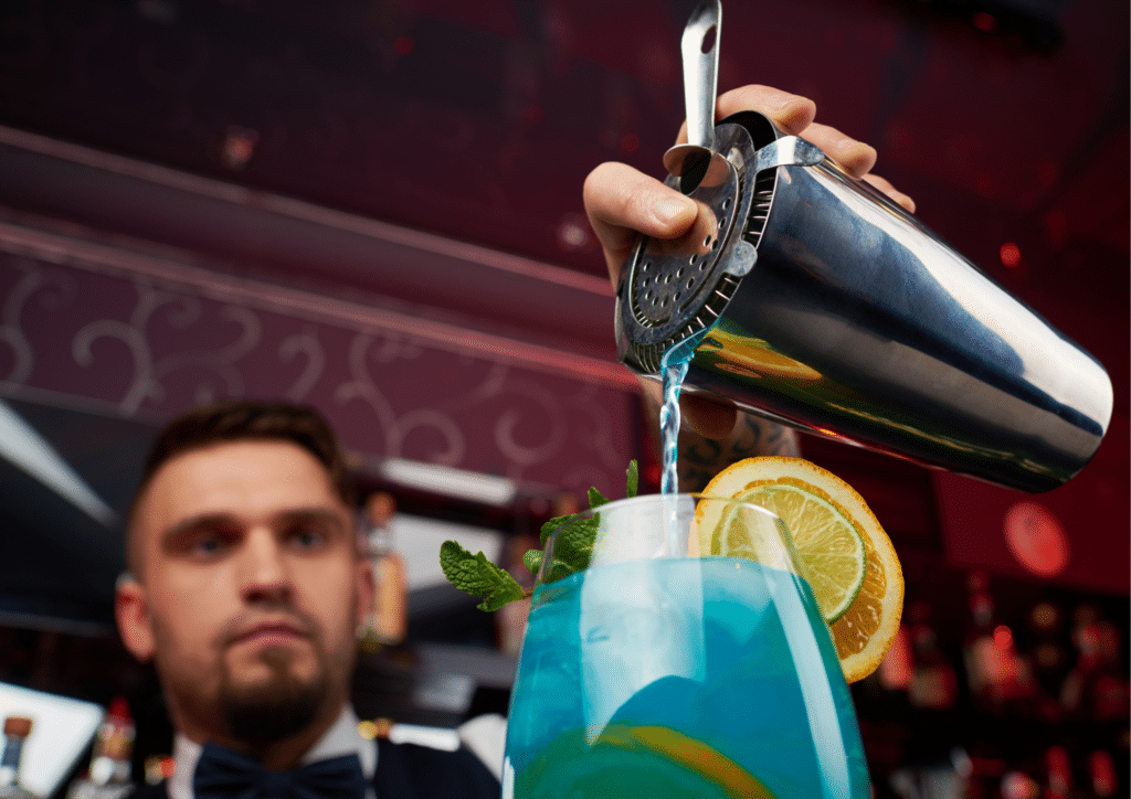 Bartender pouring a blue curacao liquor drink.