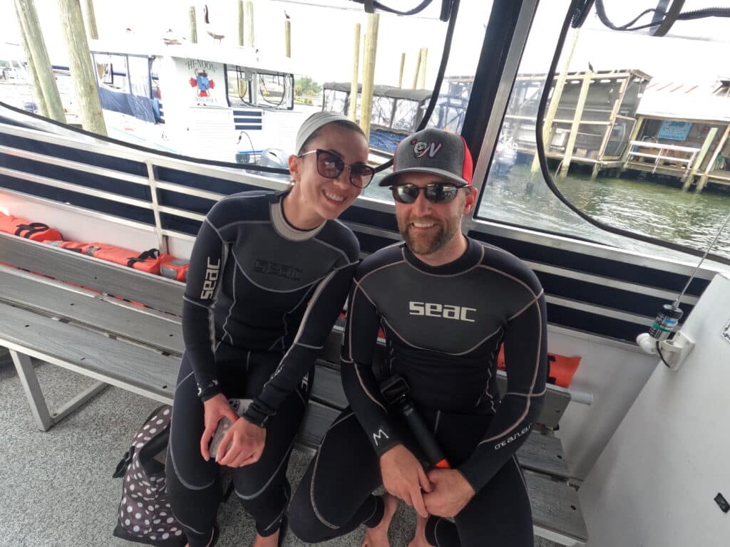 Lindsey and Zac in their wetsuits on a boat in Crystal River, Florida