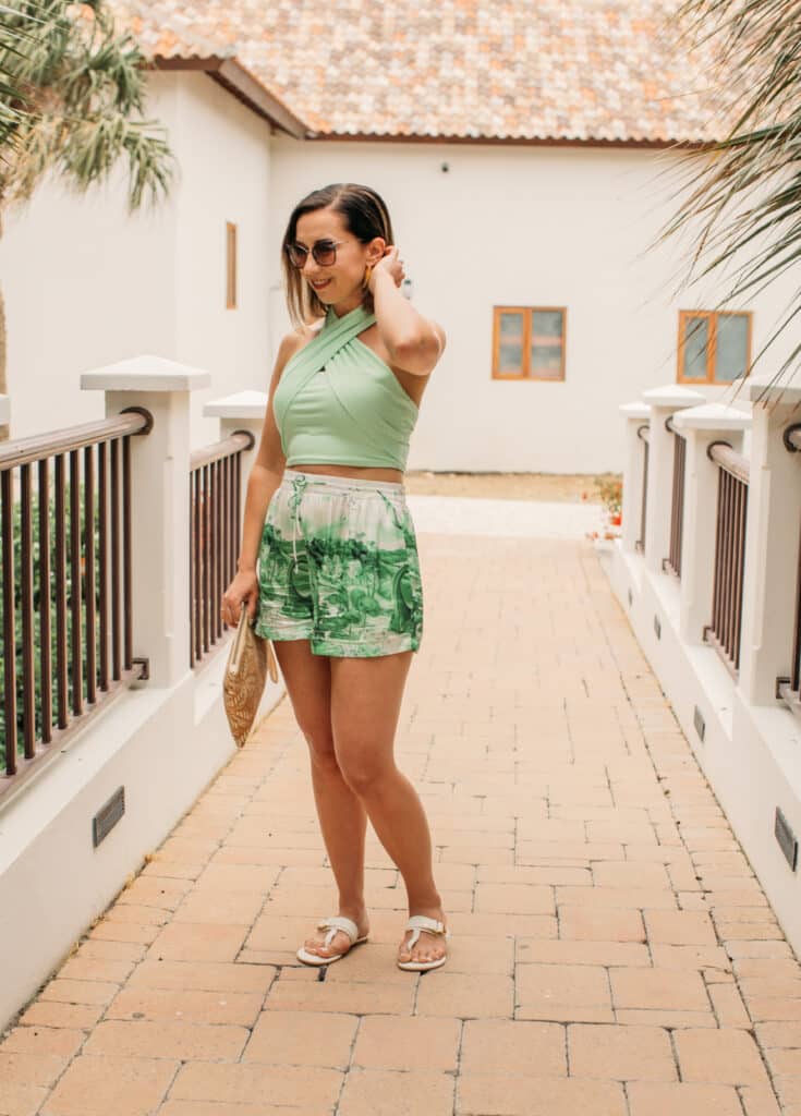 Lindsey of Have Clothes, Will Travel wearing Revolve Dinosaru shorts + Halter Tank Top