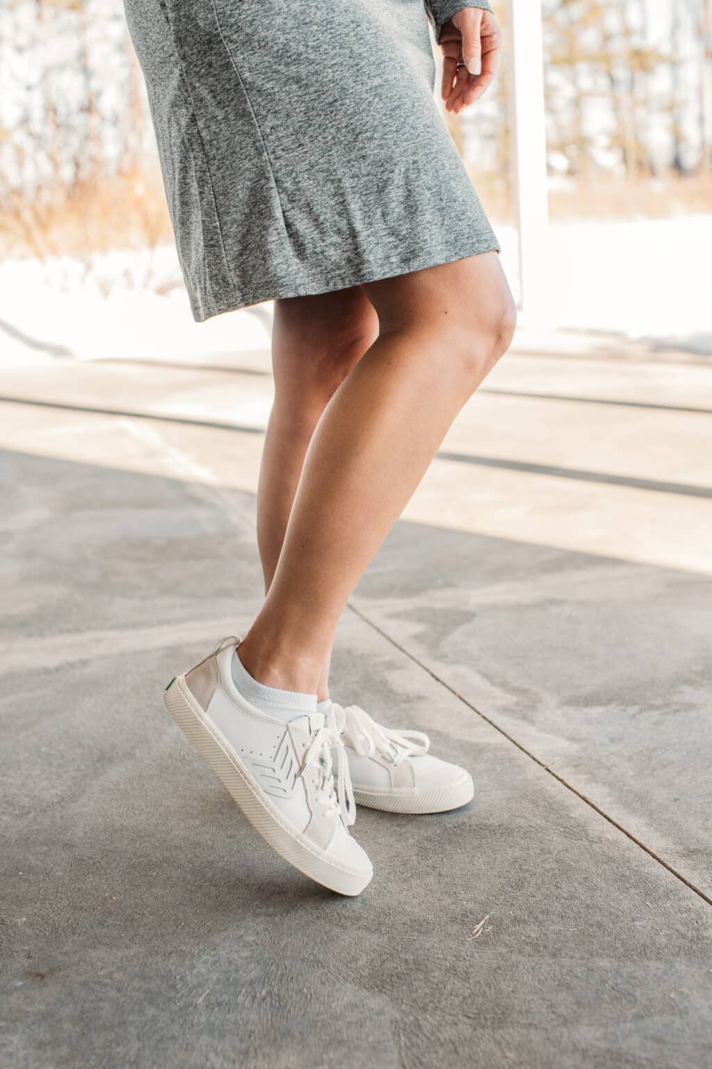 A closeup image of Lindsay's Carium sneakers. the shoes are white with off-white accents and white laces.