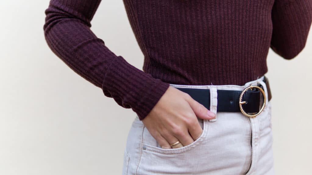 Young woman with black leather belt and purple sweater