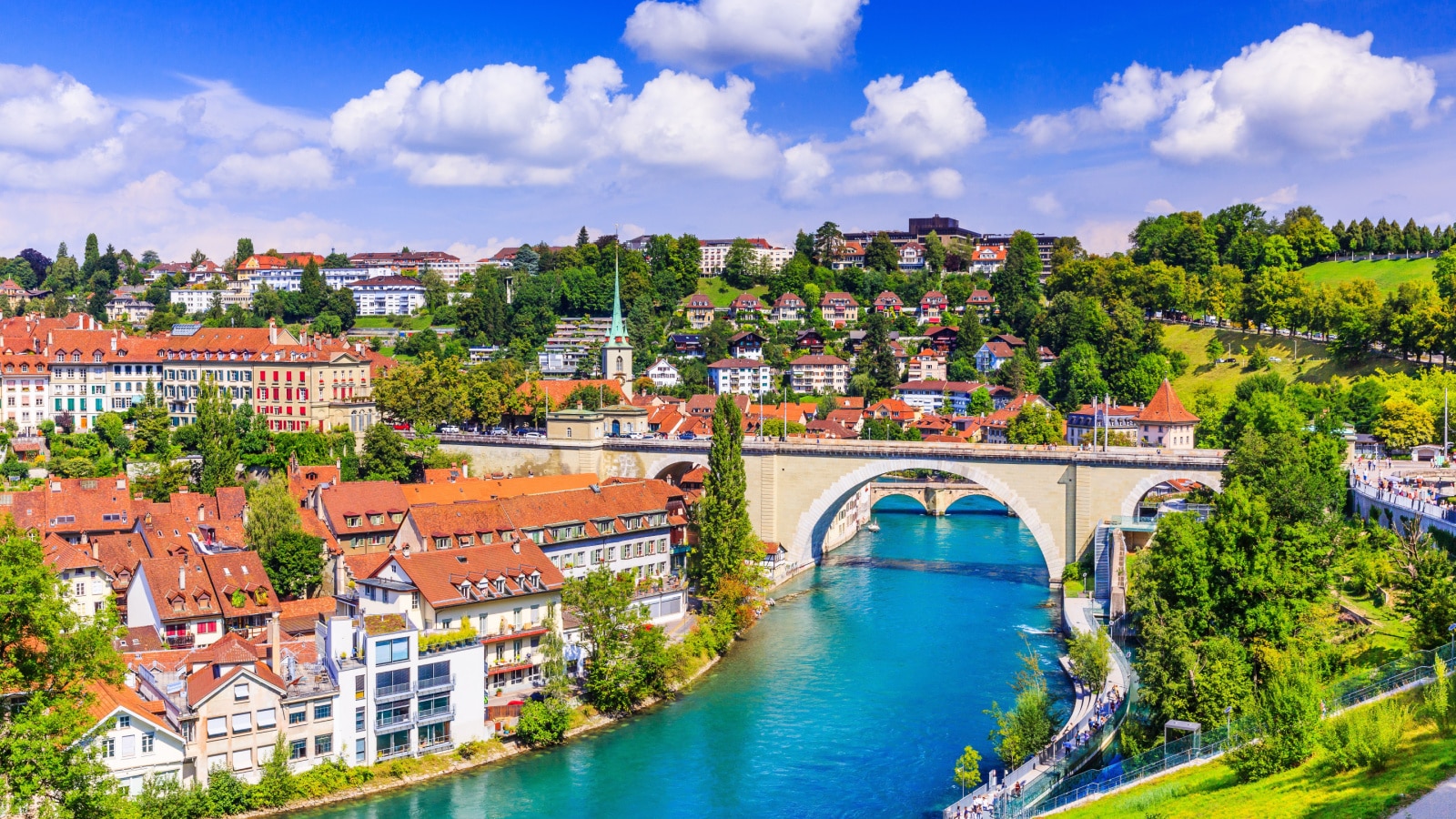 An aerial view of the old Bern, Switzerland city center and Nydeggbrucke bridge over river Aare on a picturesque, sunny day.