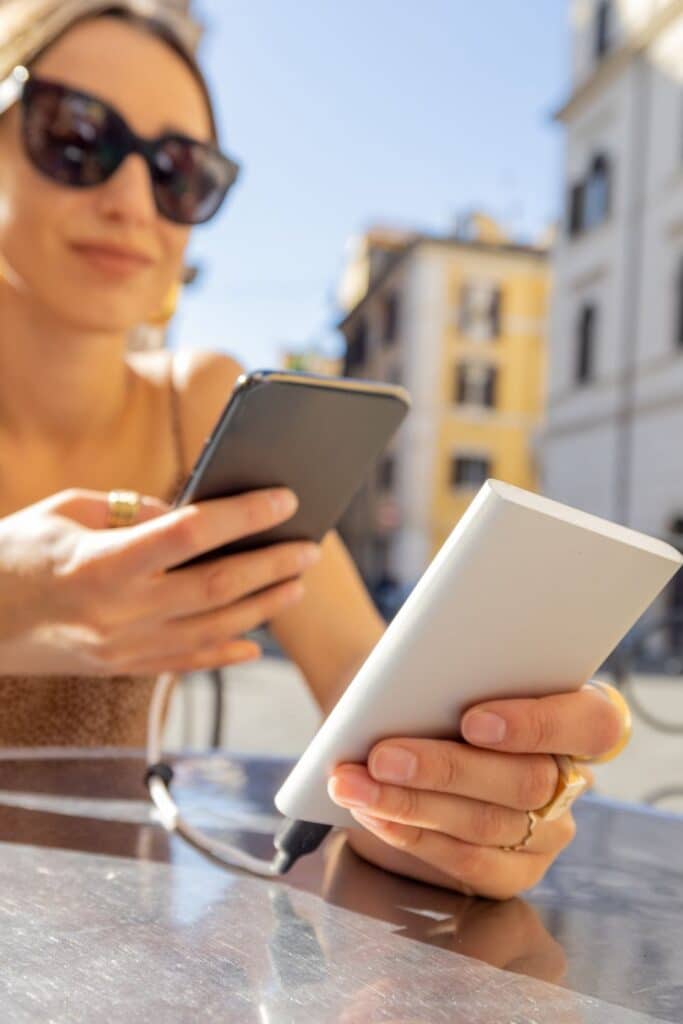 Woman using a power bank to charge her cell phone