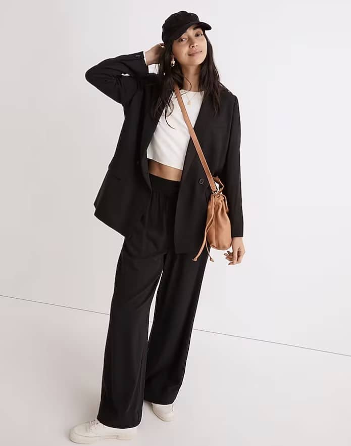 woman wearing ball cap, over sized blazer over a white top, paired with black pants from Madewell