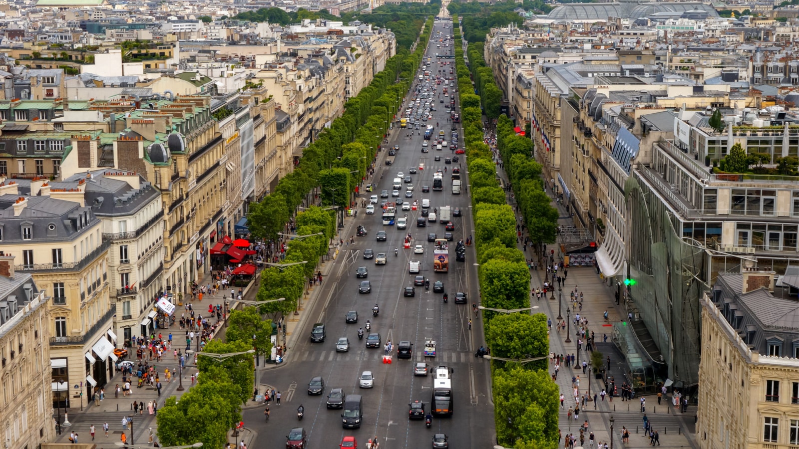 Paris, France - July 2019 - Panoramic bird's eye view above Haussmann-style townhouses on the trimmed tree-lined Avenue des Champs-Elysées, heading to Place de la Concorde and Tuileries Garden