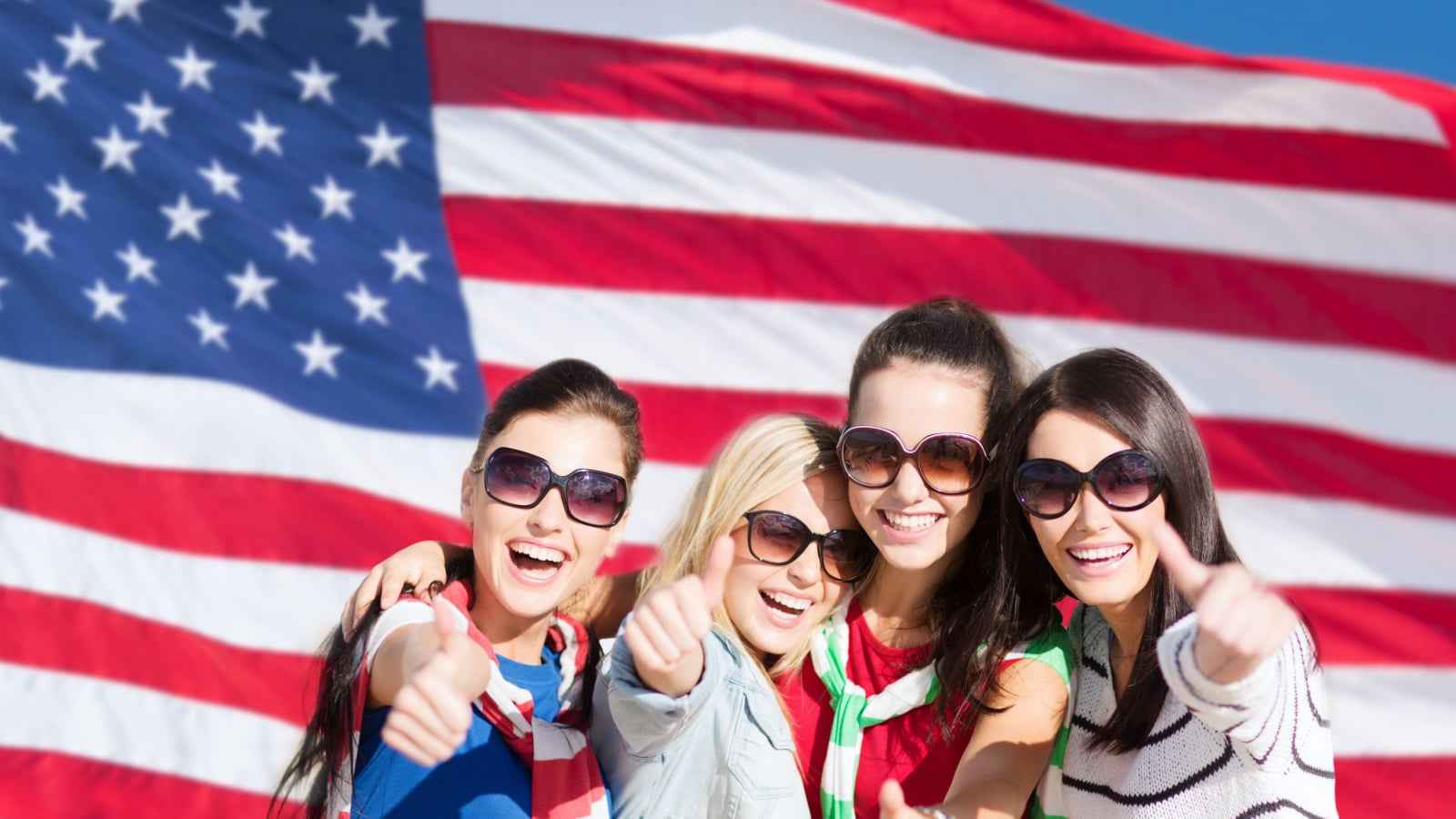 women traveling in the united states summer, holidays, vacation, happy people concept - beautiful teenage girls or young women showing thumbs up