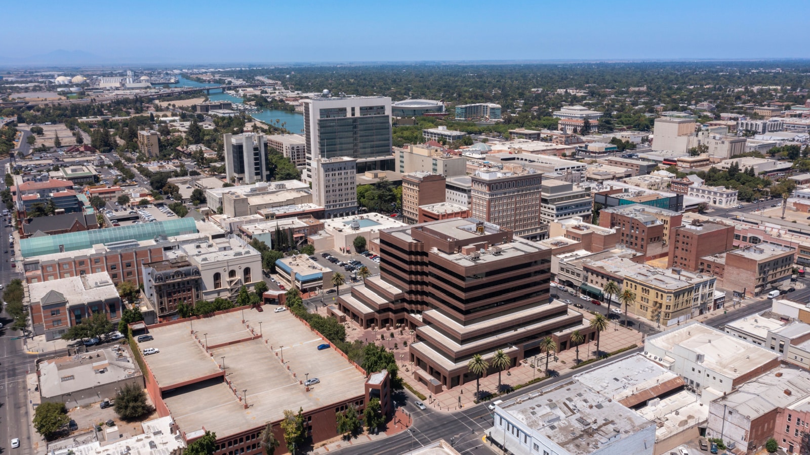 An aerial photo of the urban landscape in Stockton, California -- city blocks filled with buildings and grids of roads.