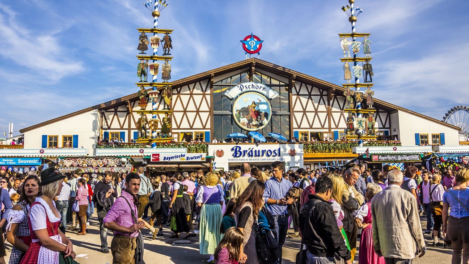 MUNICH, GERMANY - SEPTEMBER 23, 2012: Oktoberfest, Munich: One of the big beer tents. In the foreground, people are walking along, partly dressed in traditional costumes.