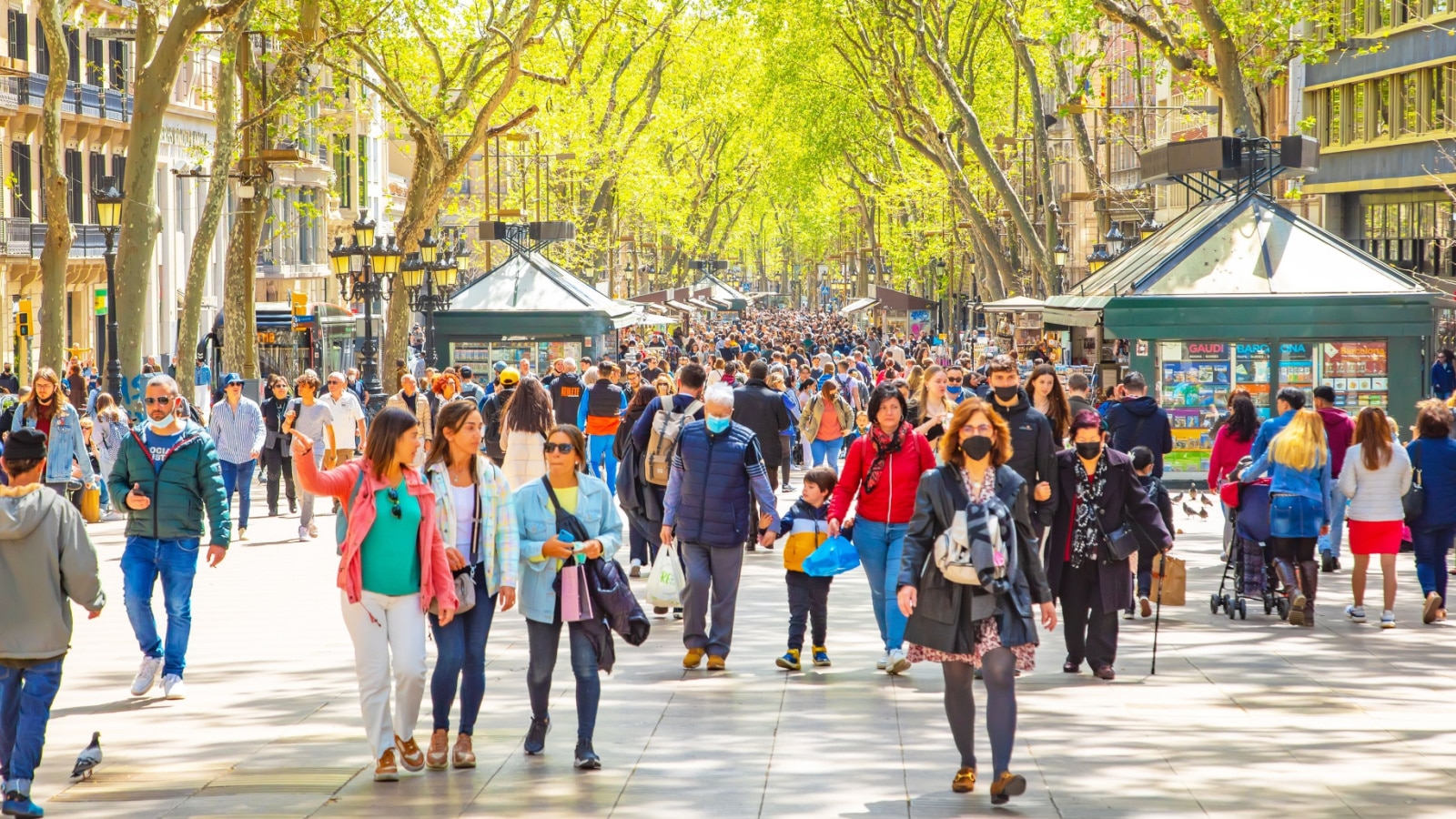 Barcelona, Spain - 11 April, 2022: La Rambla busy street photo with many walking people. La Rambla is the most popular pedestrian street in Barcelona city.