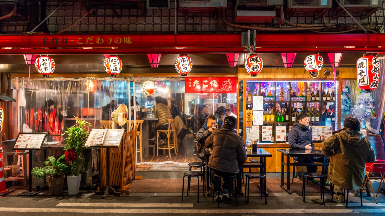 OSAKA, JAPAN - DECEMBER 27: Locals eat a late night dinner outside a restaurant on December 27, 2014 in Osaka, Japan.
